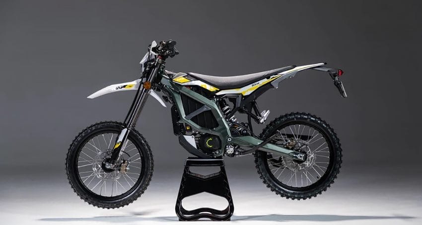 A dirt bike sitting on a stand against a gray background.