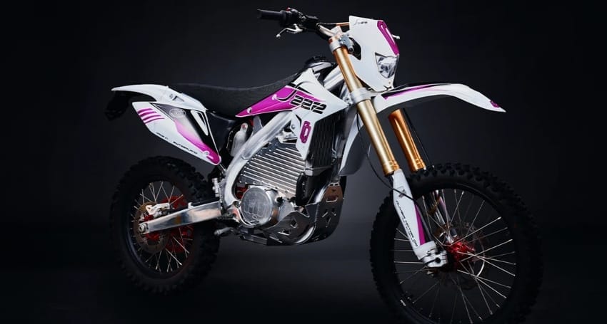 A modern electric motocross bike with white and purple livery displayed against a dark background.
