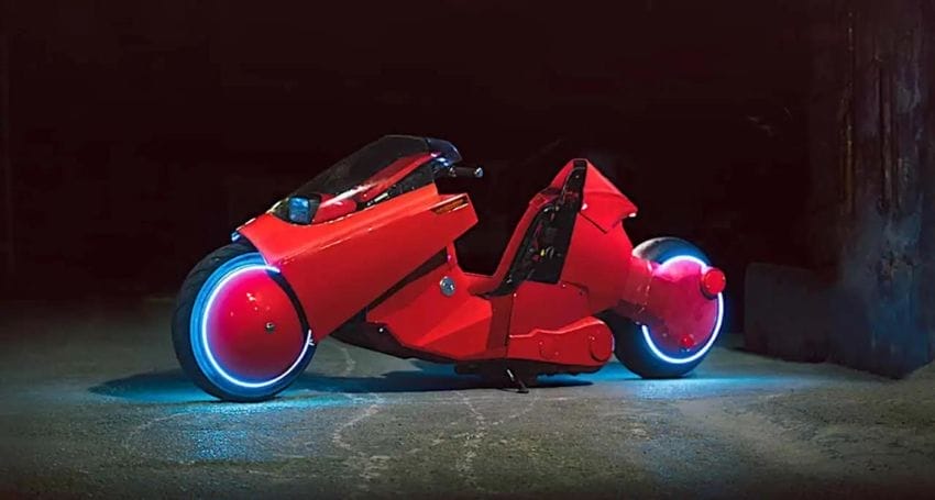 A red motorcycle with lights on it in the dark.