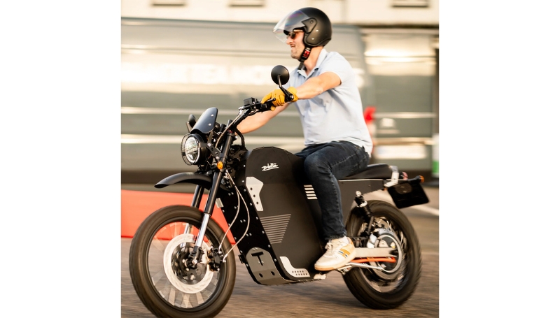 A person wearing a helmet rides a black <a href=