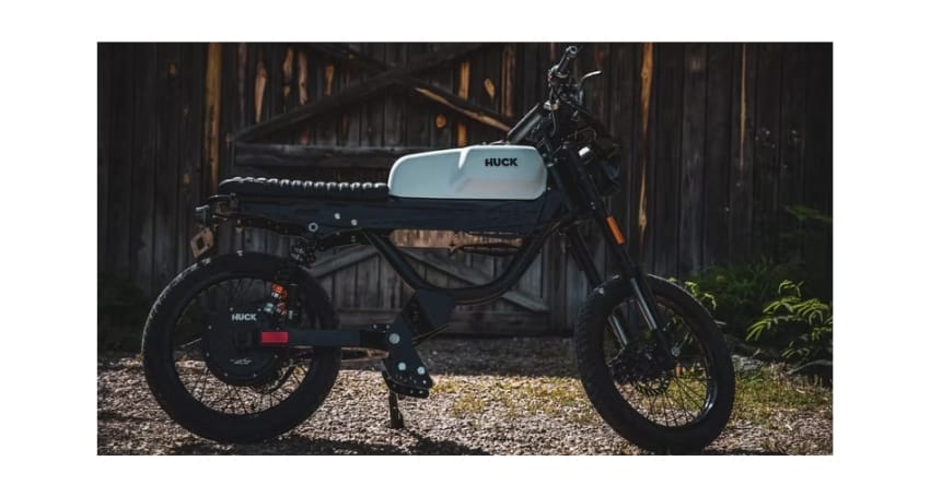 An electric bike parked in front of a barn.
