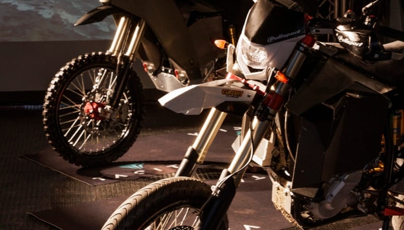 Close-up of two off-road motorcycles showing front wheels and headlights.