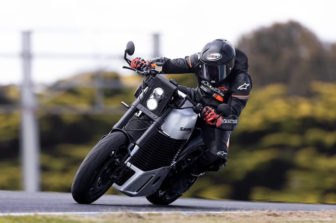 A person riding a motorcycle at high-speed on a track.