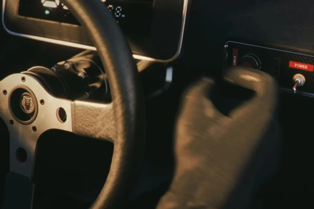 A hand on the steering wheel of an auto.