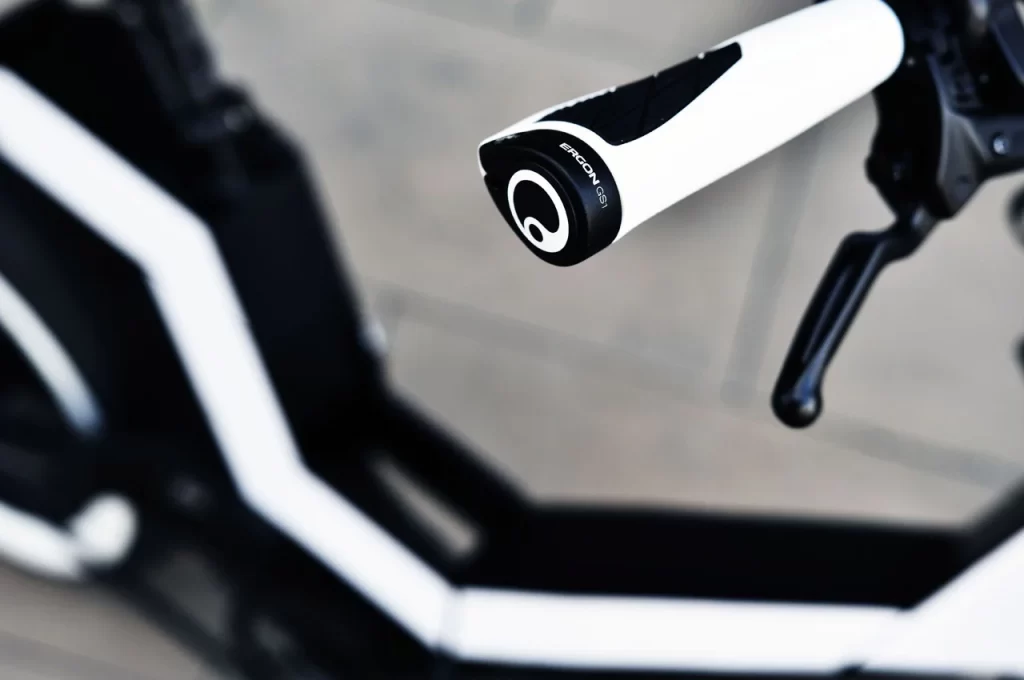 A close up of the handle of a black and white bicycle.