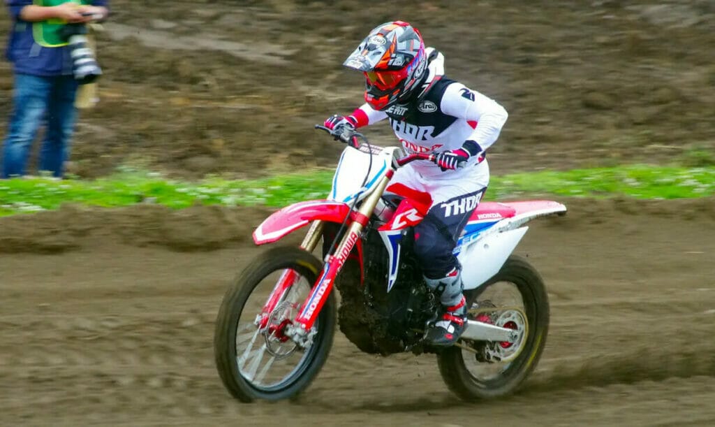 A person riding a dirt bike on a dirt track during Japan Motocross 2023.