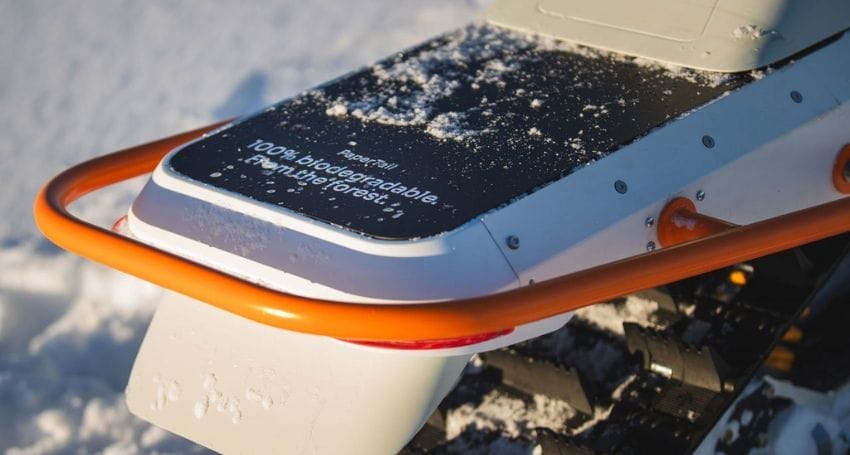 The back of an Electric Snowmobile is covered in snow.