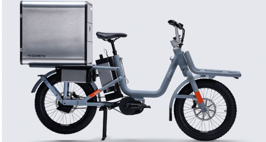 Electric cargo E-Bike with a large metal rear storage box and a sturdy gray frame, parked against a plain background.