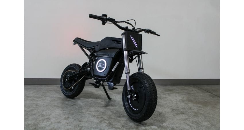 A black electric bike sitting on a concrete floor.