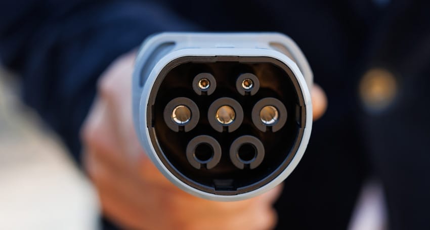 A close up of a person holding a device for EV Infrastructure development by the UK Government.