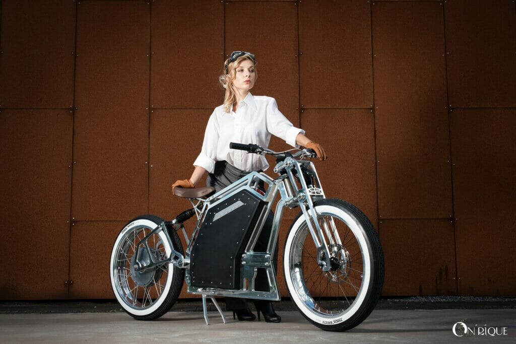 A woman is posing next to an electric bike.