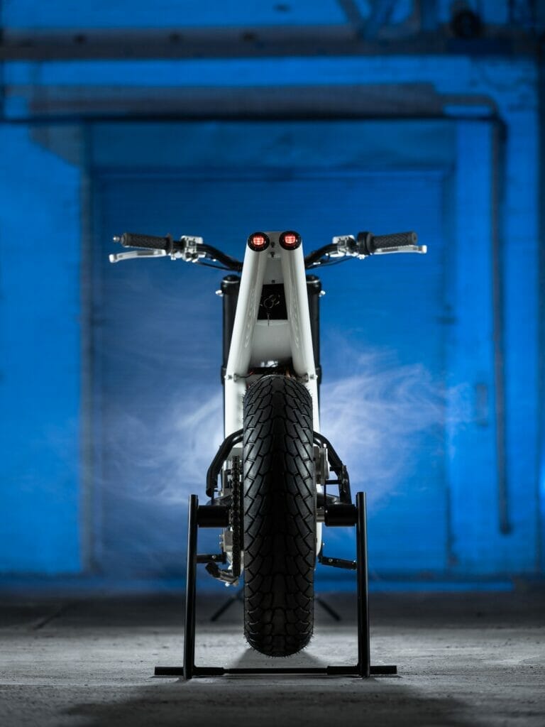 Untitled's Electric Supermoto Vision is parked in front of a blue wall.