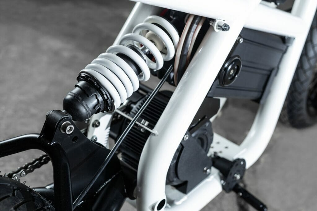 A close up of an electric bicycle with a spring attached to it, embodying Untitled's Electric Supermoto Vision.