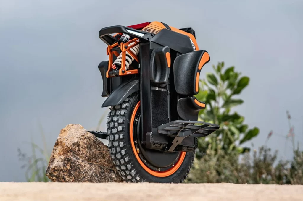 A powerful black and orange InMotion Adventure Unicycle conquering rocky terrains.
