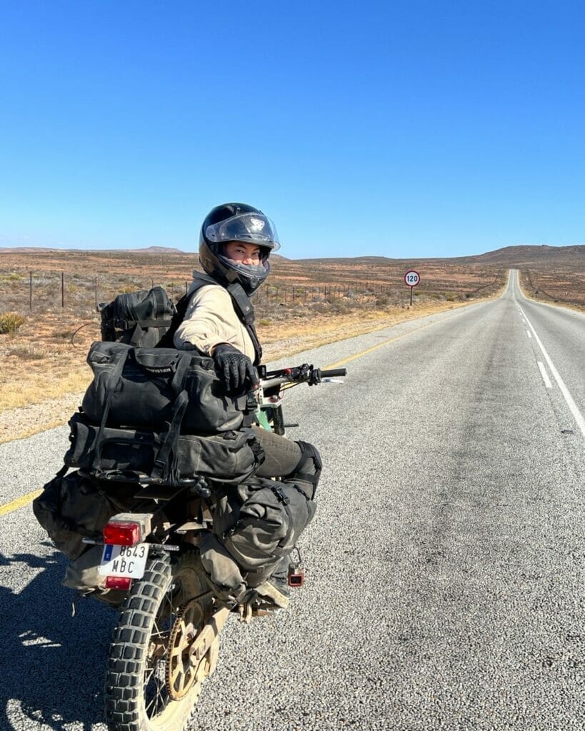 A man riding a motorcycle down a deserted road.