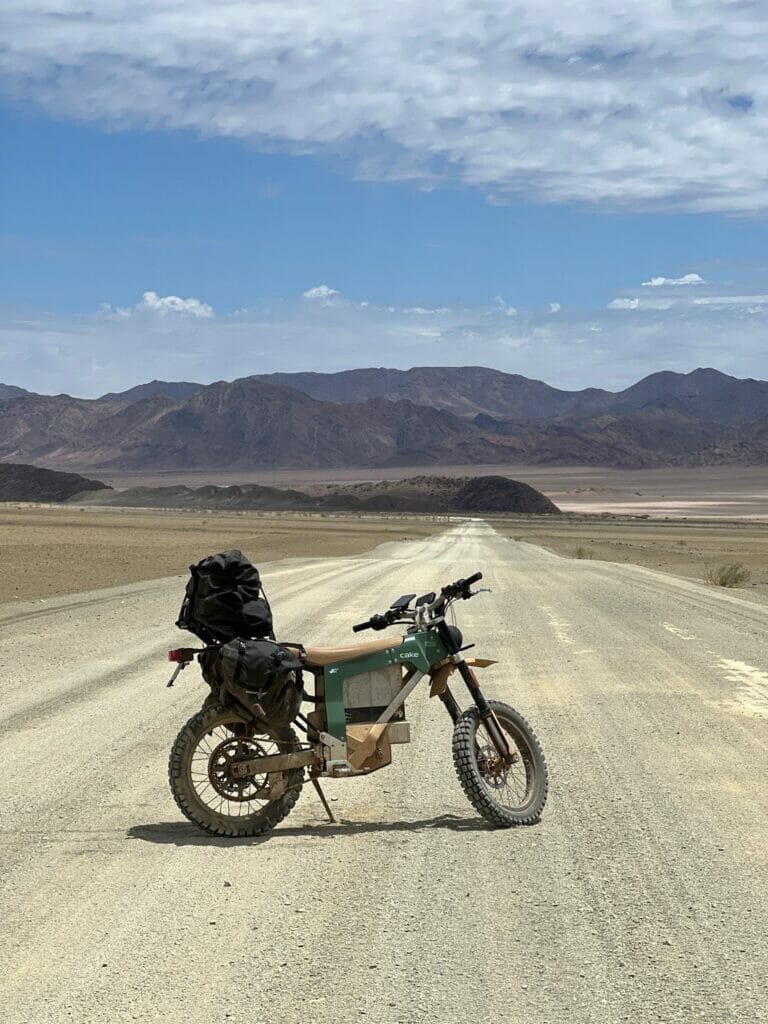 A motorcycle parked on a dirt road in the desert.