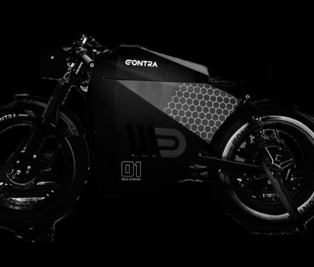 A black and white motorcycle sitting on a black background.