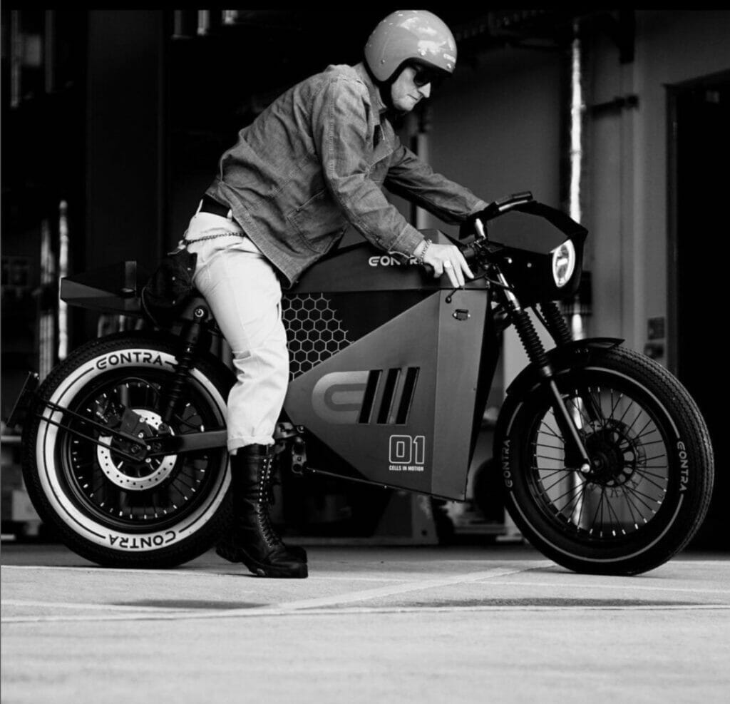 A man sitting on a motorcycle in a garage.