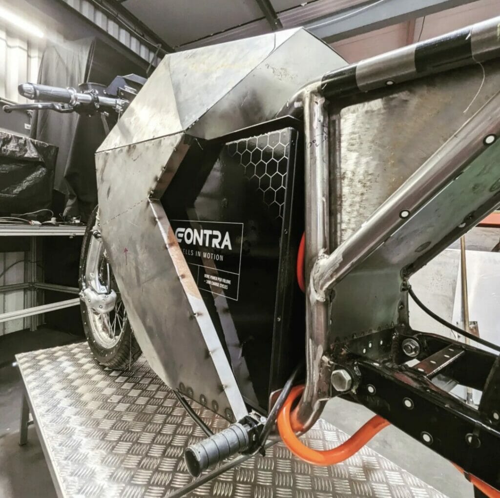 A motorcycle is sitting on a platform in a garage.