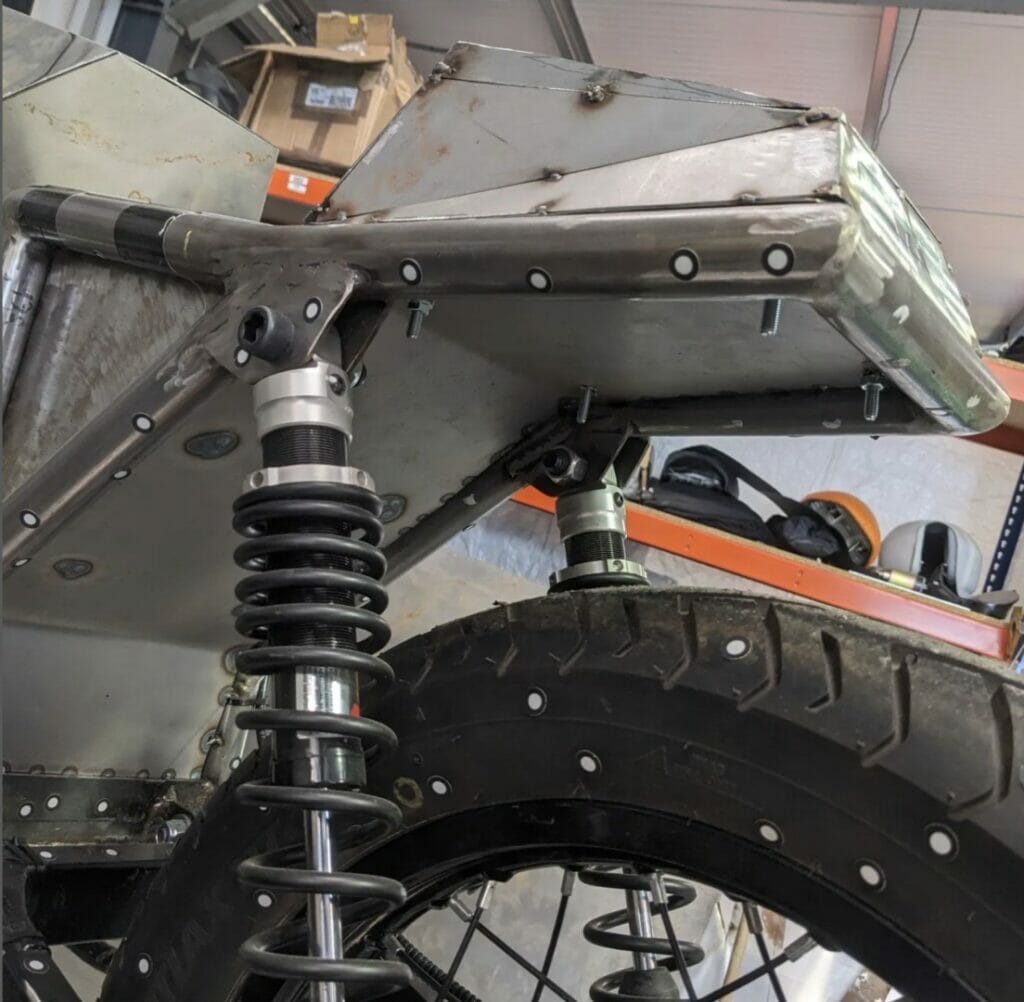 A motorcycle with a rear suspension attached to it.