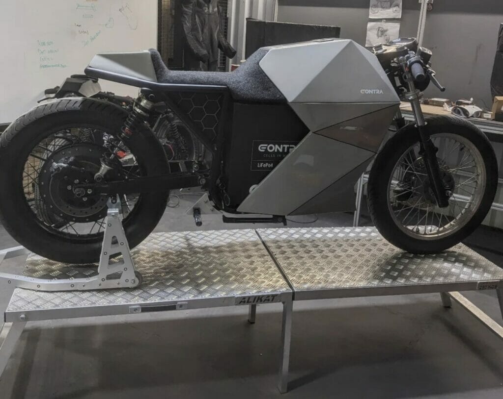 A motorcycle is sitting on a platform in a garage.