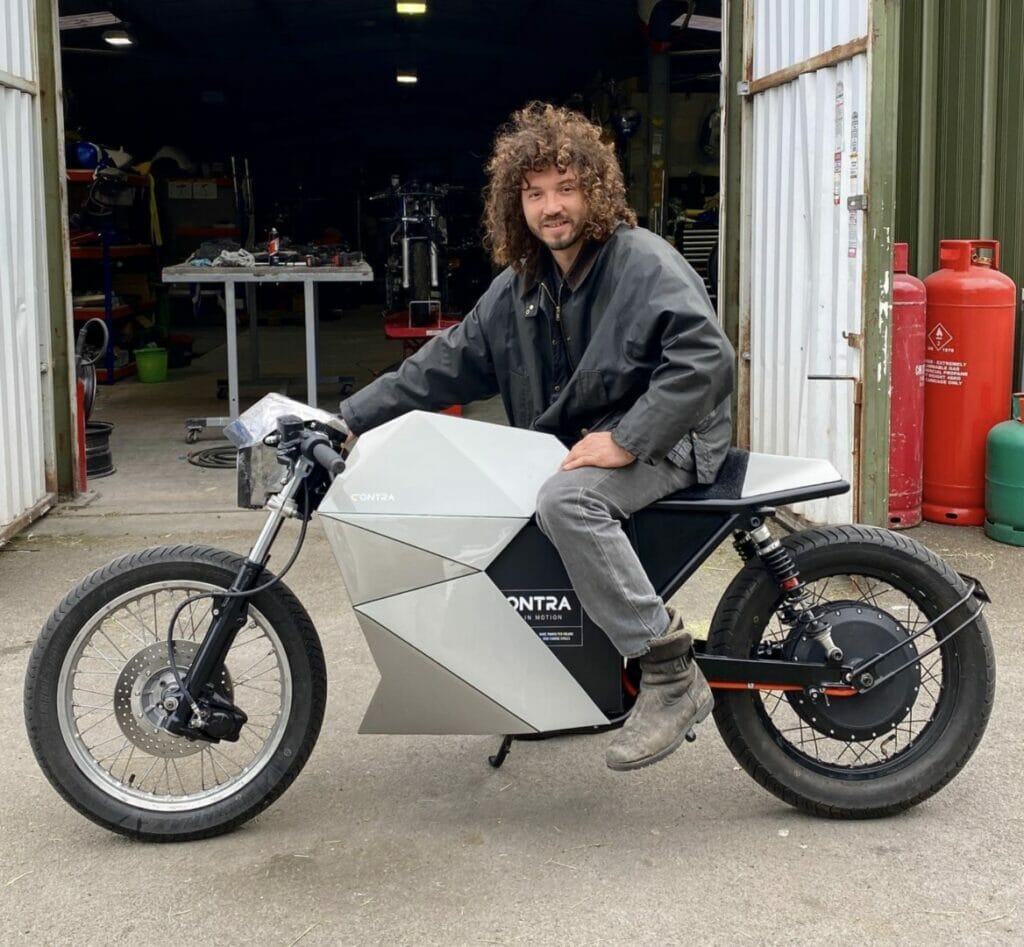 A man sitting on a motorcycle in a garage.
