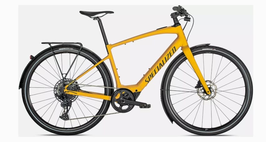 A yellow Specialized Turbo Vado SL 5.0 electric bike with a black seat, rear rack, disc brakes, and a Shimano gear system—touted as the lightest electric bike—is displayed against a plain white background.