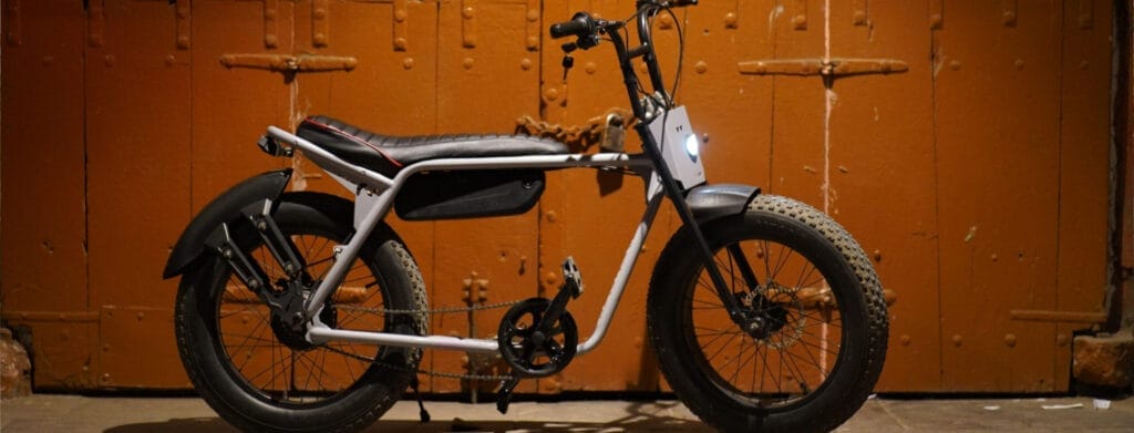 A bicycle is parked in front of an orange door.