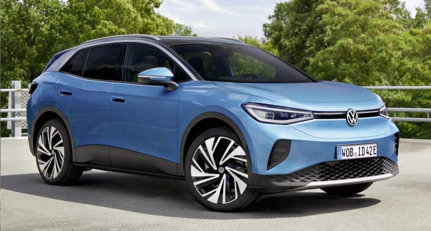 A blue volkswagen id.4 electric suv parked outdoors with trees in the background.
