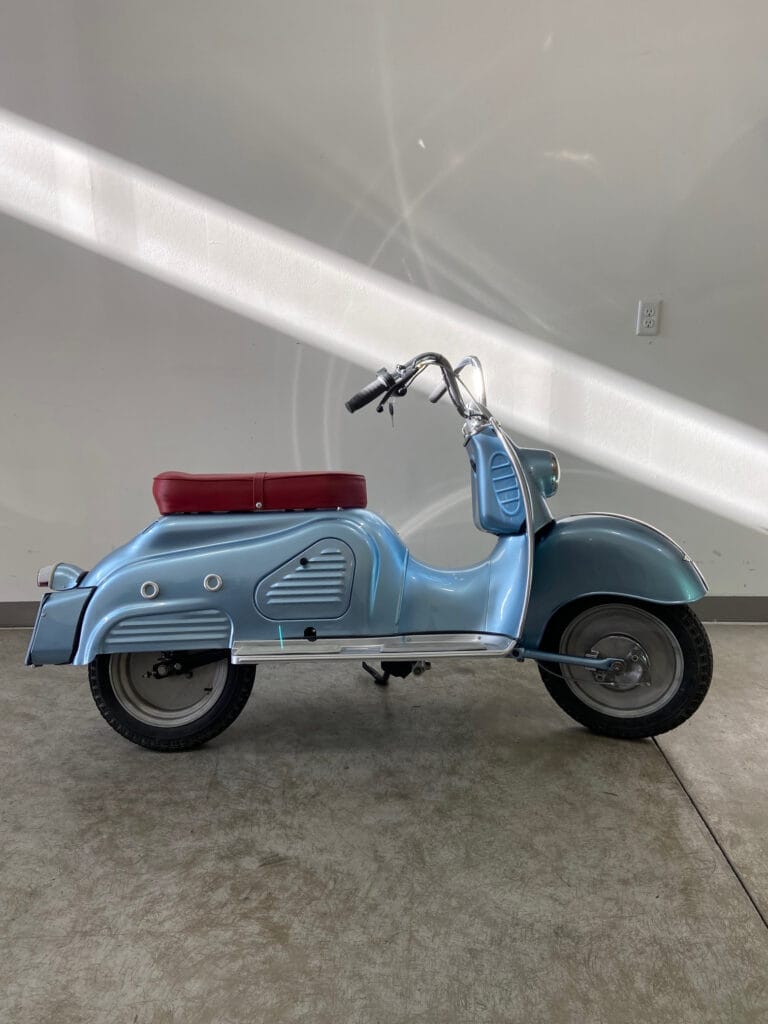 A blue moped electrifies a garage.