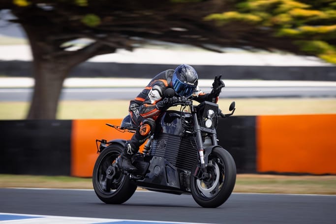 A person riding a C-Series Triumph motorcycle on a track.