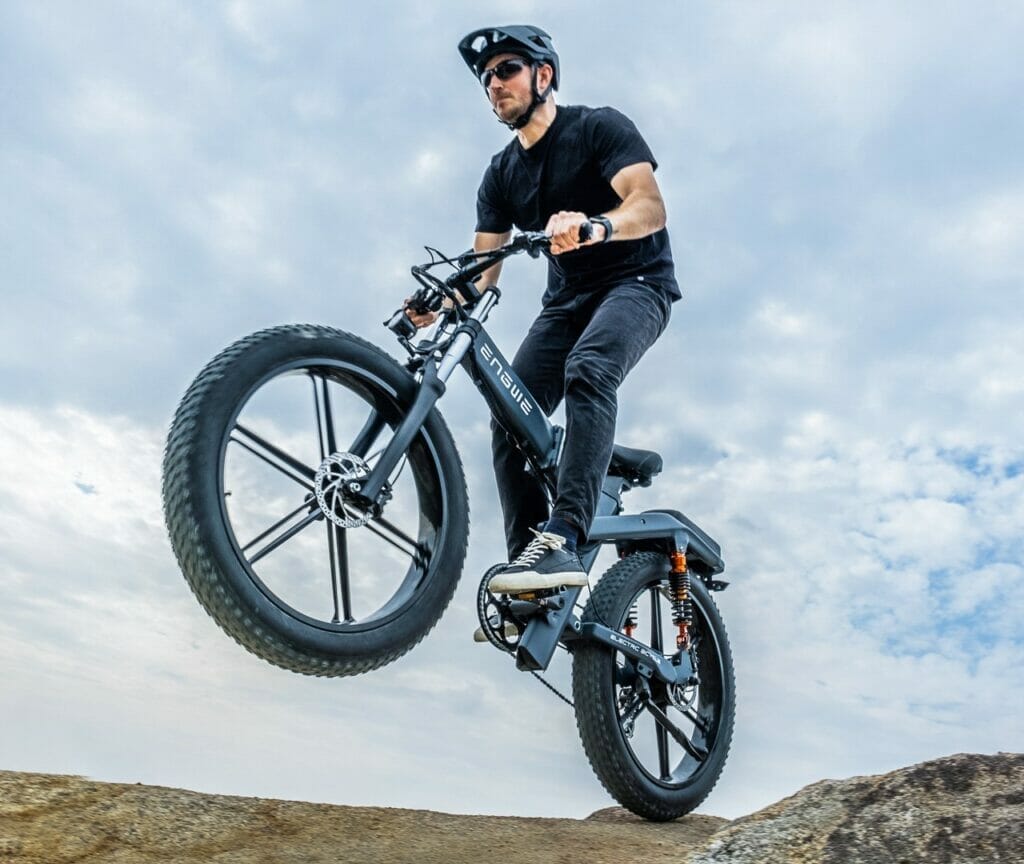 a man flying through the air while riding a bike down a dirt road