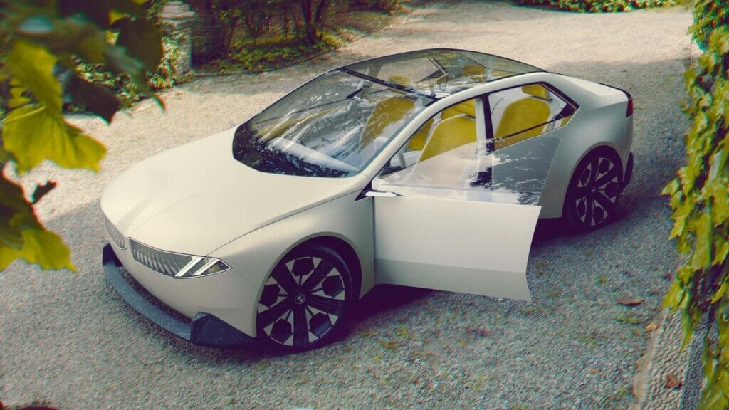 A futuristic BMW Vision Neue Klasse Concept car with a minimalist design is parked in a driveway, featuring a giant head-up display.