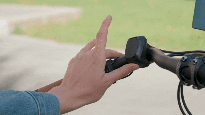 A person's hand on the handlebar of a bicycle.