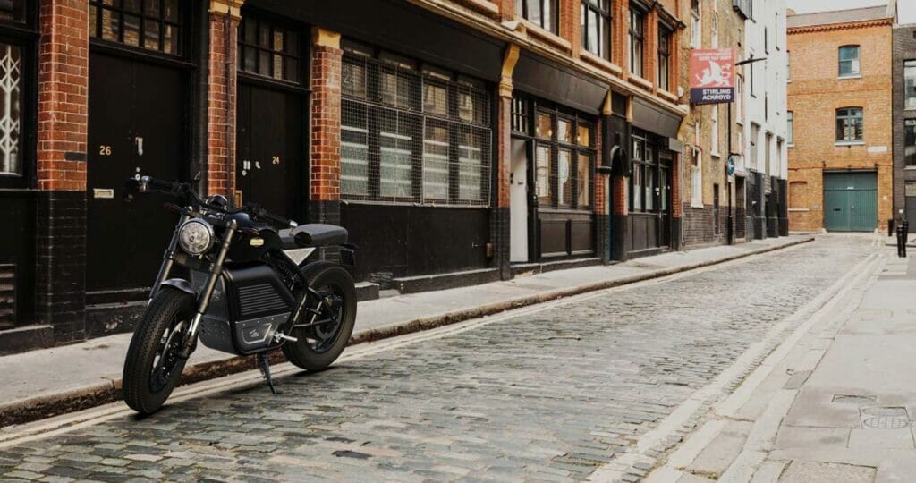 Black motorcycle, cobblestone street.