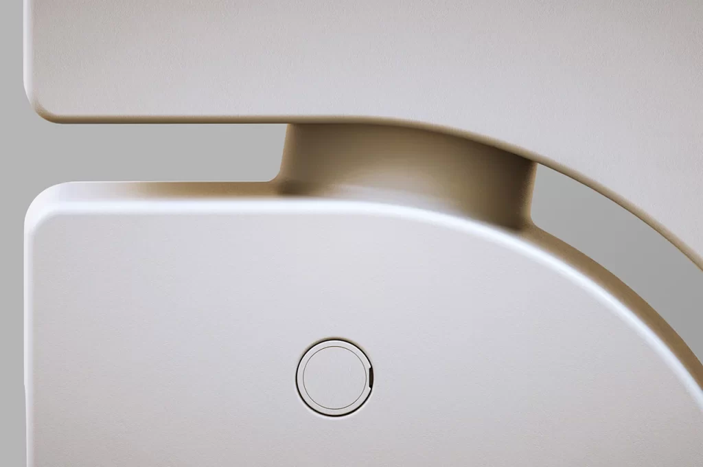 A close up of a toilet seat with a button on it.