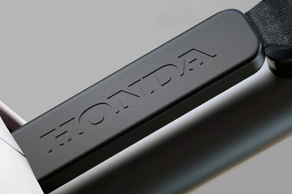 A close up of the Honda logo on the handlebar of a motorcycle.