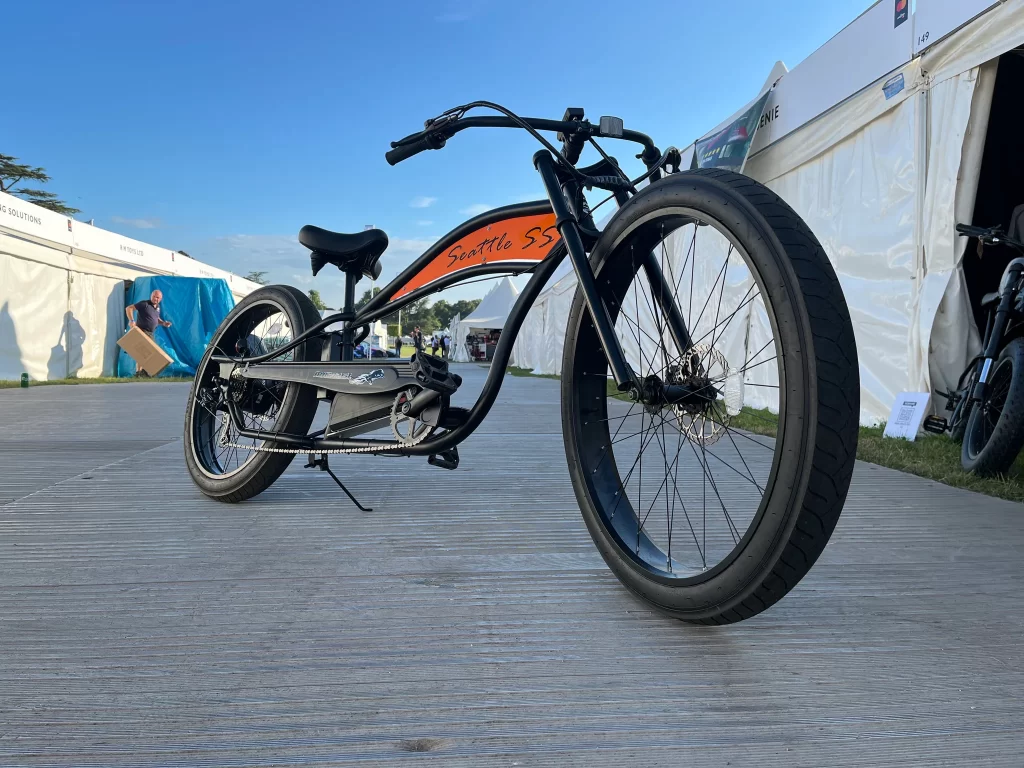 A black and orange bike parked in a parking lot.