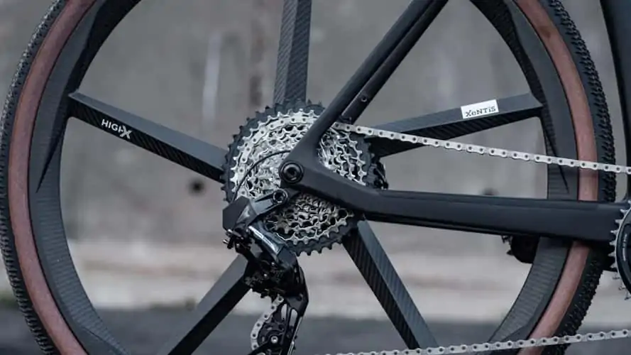 A detailed close up of a bicycle wheel with a chain, showcasing the interlocking mechanism between the gears.