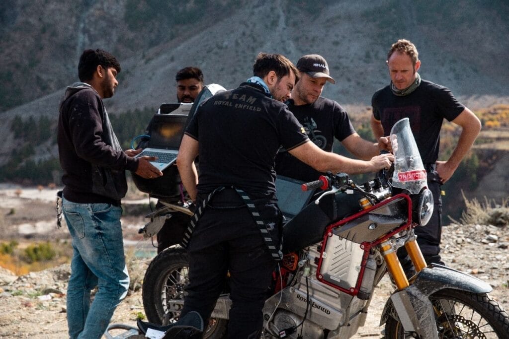 A group of men standing around a motorcycle.