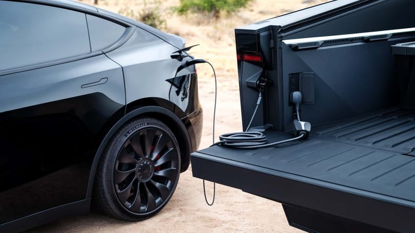 A black Tesla Model S, designed by Elon Musk, parked in the back of a truck.