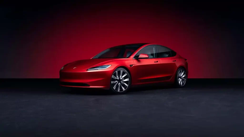 Tesla unveils the red Model 3 with enhanced range, set against a red background.