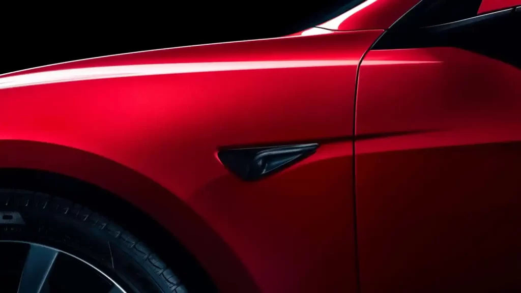 A close up of a red Tesla sports car.