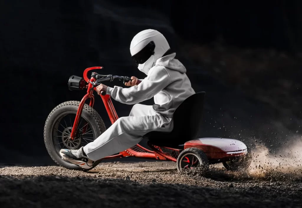 A man in a white suit riding a red tricycle.