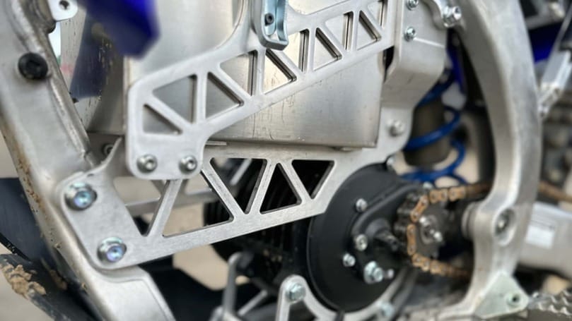 A close up of the chain on a dirt bike.