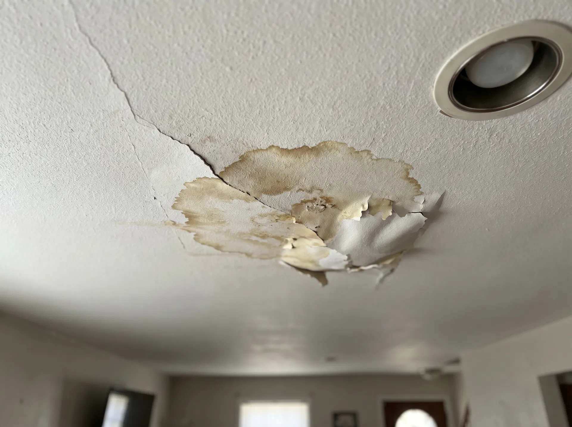 Water-damaged ceiling with large brown stain and cracked drywall – O'Fallon IL area
