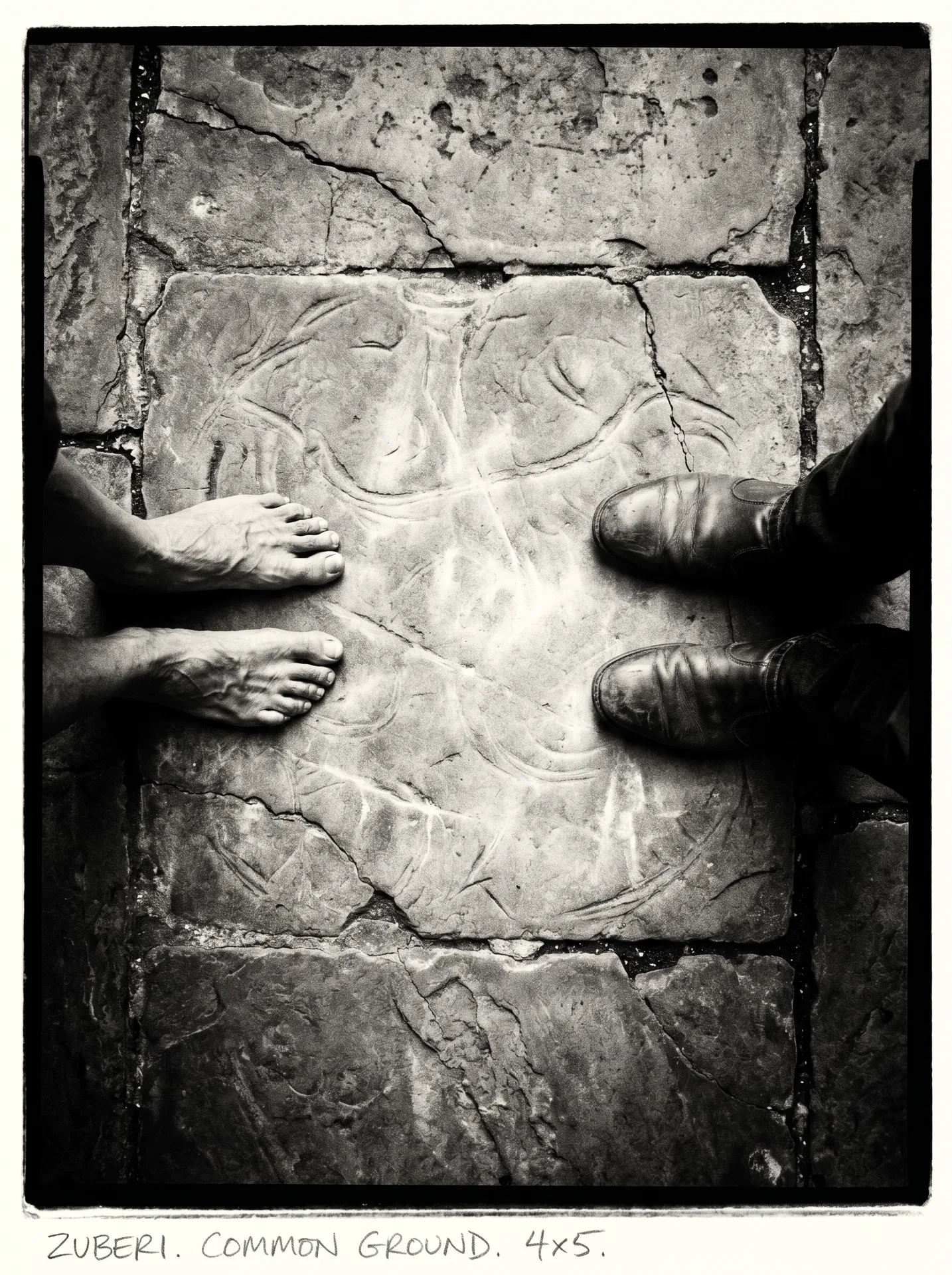 Large format monochrome photograph of a civic plaza. Multiple figures cross the same stone grid from different directions. The floor holds everyone equally. Fuji X-Pro1 aesthetic, Gordon Parks lineage.