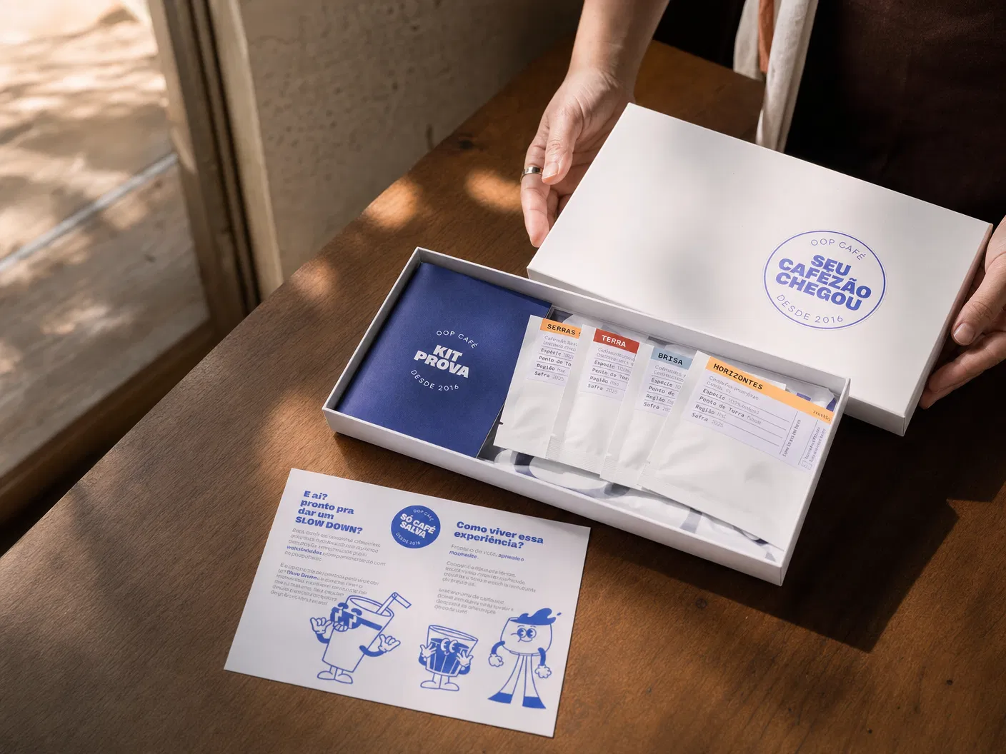 Kit Prova OOP sendo segurado nas m�os, com caixa branca e elementos azuis da marca.