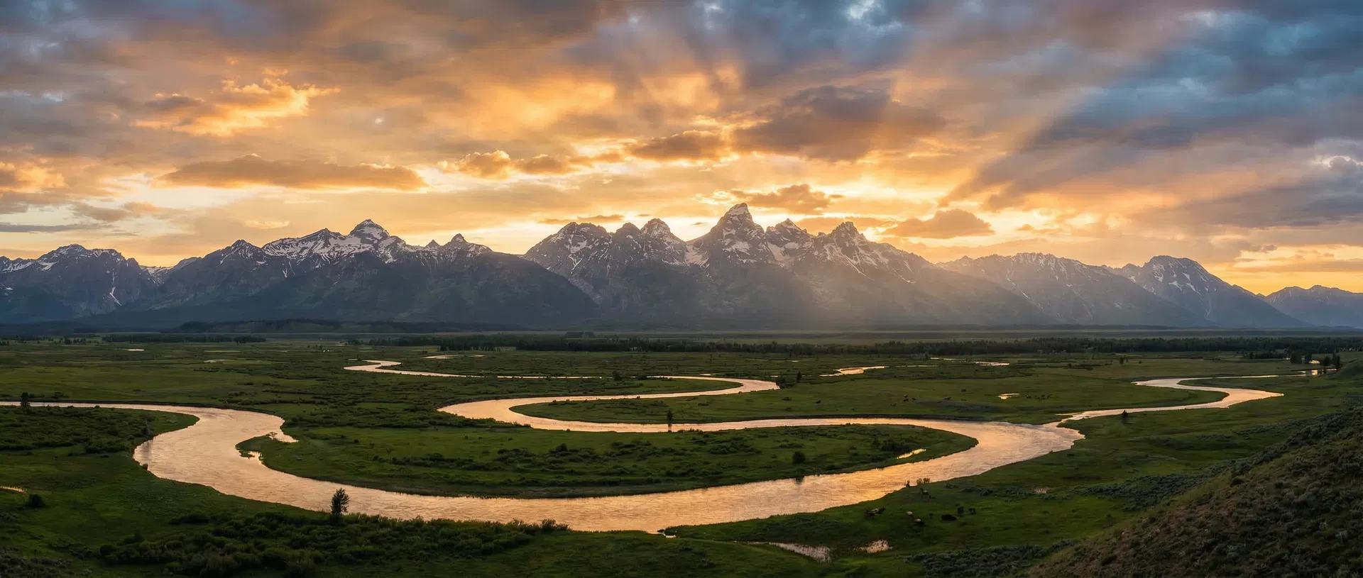 Snake River winding through the Grand Teton mountain range at golden hour