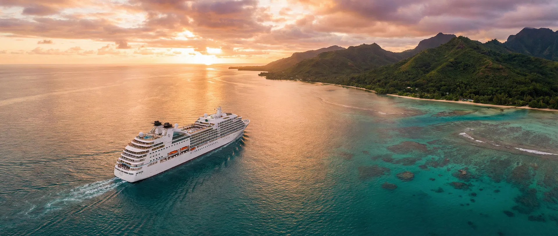 Luxury cruise ship sailing through turquoise waters at sunset